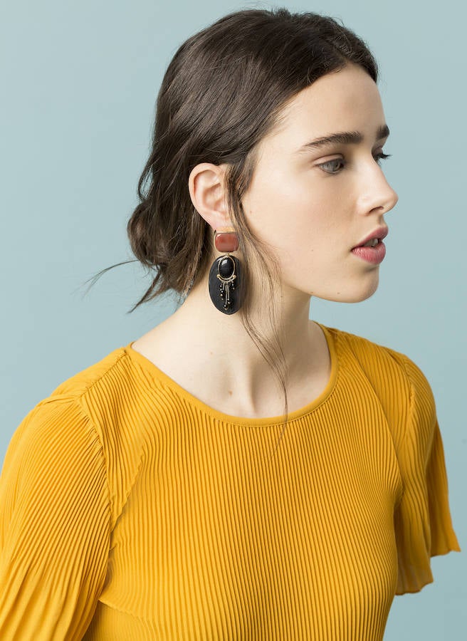 Plisado y con manga corta, este modelo se acompaña de unos grandes pendientes en la campaña de la firma