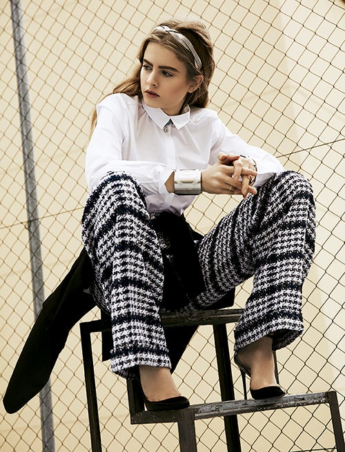 El pantalón de tweed, la diadema y el brazalete son de Chanel. La camisa es de Cos y el collar, de Dior. Chaqueta anudada a la cintura, de Adolfo Domínguez y zapatos de Zara. En la mano dcha., anillos Ararat. En la izq., reloj de Sandoz y sortijas de Aristocrazy. Estilismo: Carolina Badía. Maquillaje y peluquería: Iván Gómez (Kasteel Agent) para Balmain Paris Styling Line y Chanel.