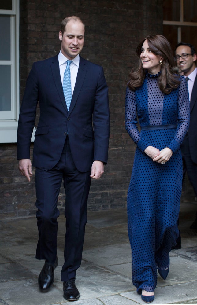 Al caer la noche, Kate Middleton cambió el rojo por el azul y apareció, impresionante, con este mono de plumeti azul marino de la diseñadora hindú Saloni Lodh, que combinó con salones de ante a juego de Rupert Sanderson.