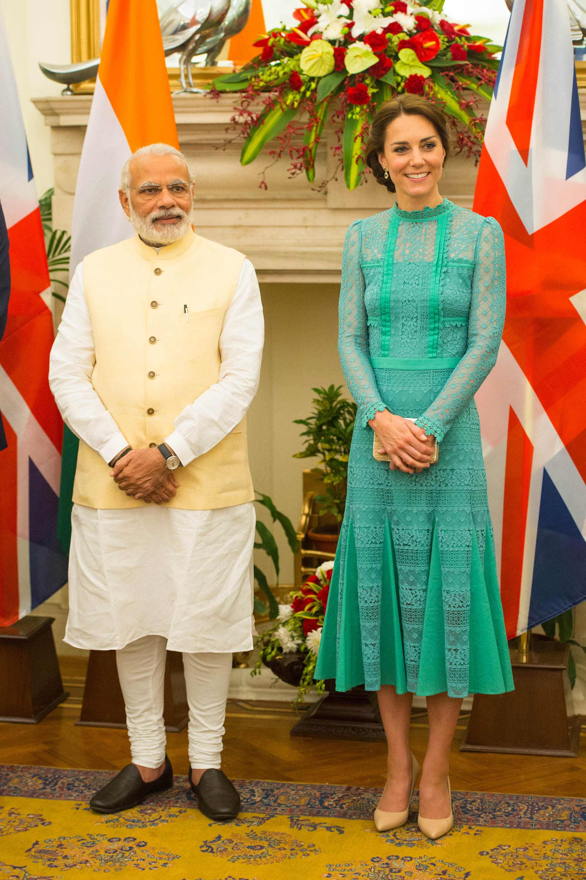 Para acudir en Nueva Deli a una comida con el Primer Ministro de la India, Narendra Modi, la Duquesa de Cambridge apostó por un elegante vestido midi en encaje verde esmeralda de una de sus firmas fetiche, Temperley London. Los complementos comodín, en un tono beige neutro: salones lisos y original clutch de rafia de LK Bennet.