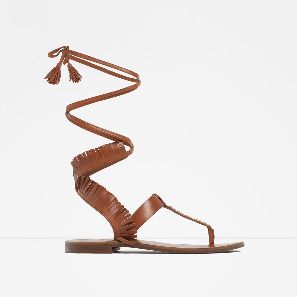 Unas sandalias de tiras que se elevan por el gemelo quedan quenial con unos shorts vaqueros (Zara, precio 35'95€)