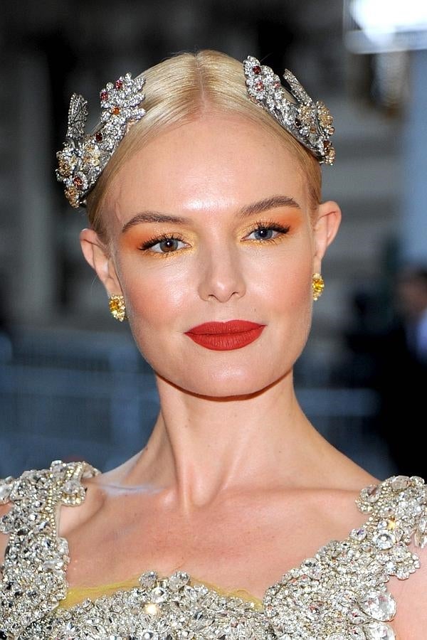 Kate Bosworth ha lucido un recogido pulido con raya en el medio y adornado con accesorios joya y un llamativo maquillaje: labios rojos y ojos con sombras en tono amarillo y naranja.