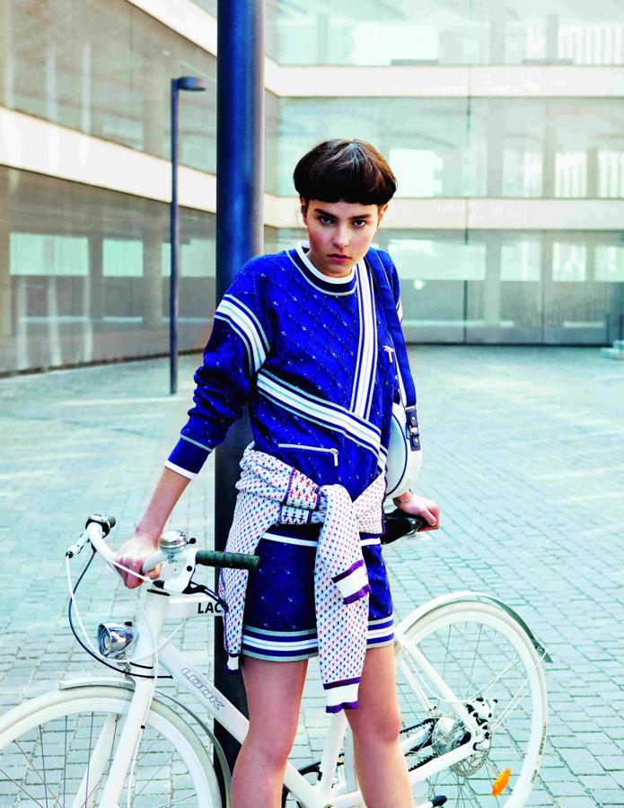 Total look de Chanel, formado por sudadera, falda y jersey, con brazalete plateado y bolso redondo. La bicicleta es un modelo de Lacoste. Maquillaje y peluquería: Estrella Elorduy para Dior, label.m. Manicura: The Pink Peony y Balbcare. Estilismo: Débora Traitè