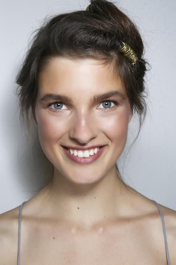 Look: Un maquillaje natural que ofrece un aspecto saludable. El pelo se agrupa informalmente, dejando mechones sueltos. Plus: A uno de los lados, la goma elástica dorada queda como adorno del peinado.