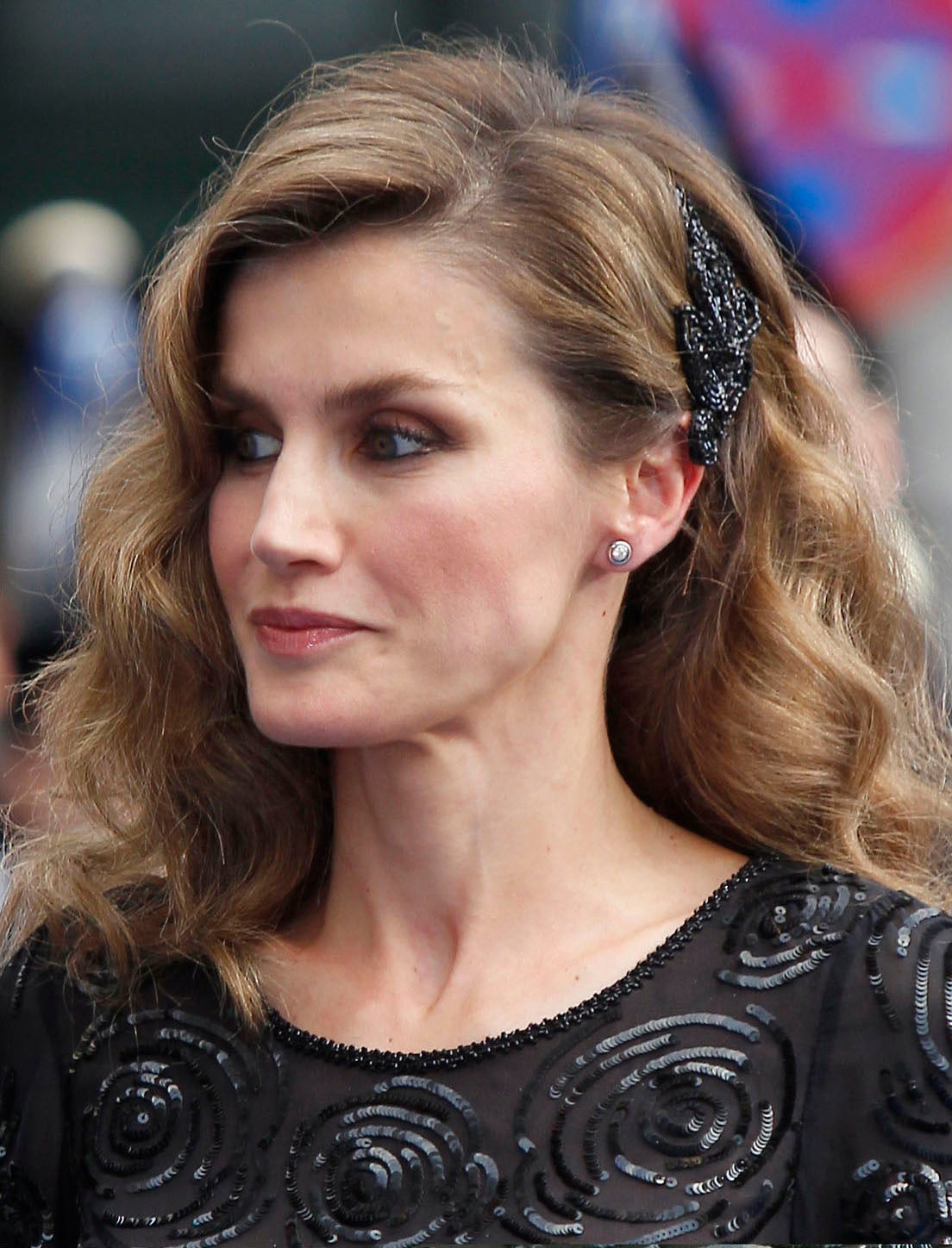 La reina Letizia con un bonito pasador negro, recogido su melena a un lado.