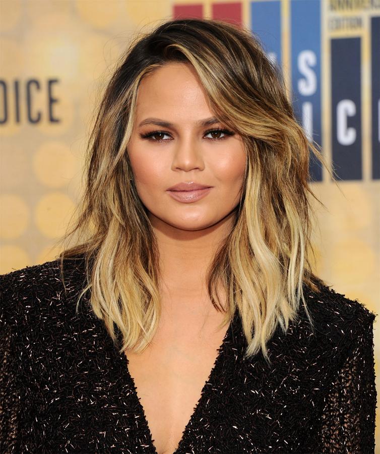 La modelo Chrissy Teigen con un long bob con mechas y peinado con raya a un lado y ondas rotas.