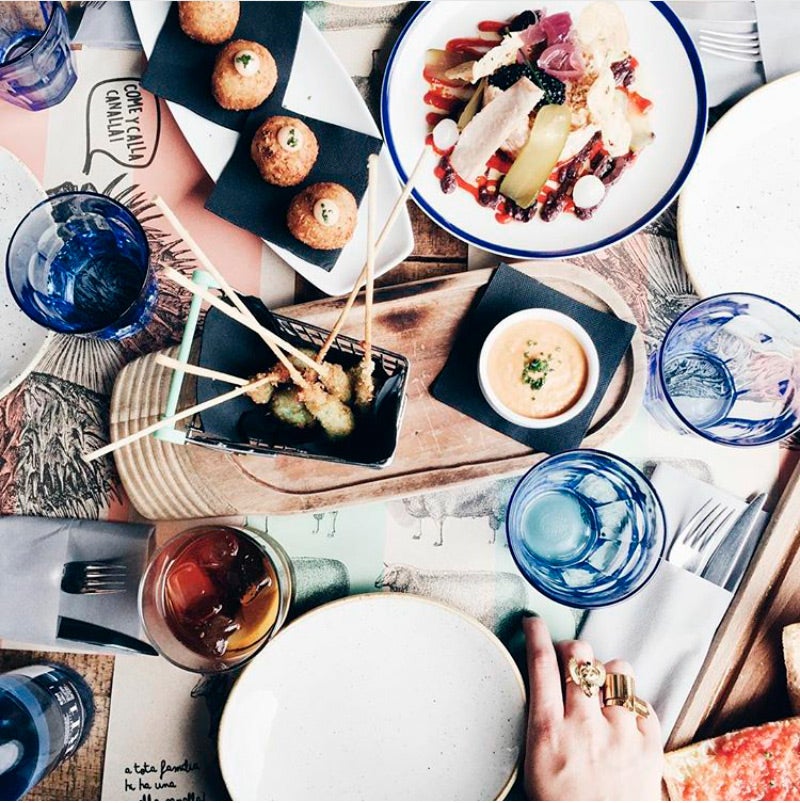 Una fotografía cenital de una mesa con comida muy apetecible.
