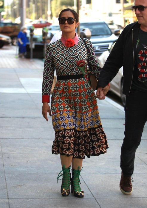 Digamos que este vestido de Gucci no es fácil de llevar, pero si a eso le sumas esos zapatos abotinados con cordones y lacito dorado que se ha puesto Salma Hayek para dar un paseo por la calle, el efecto es cuanto menos, recargado.
