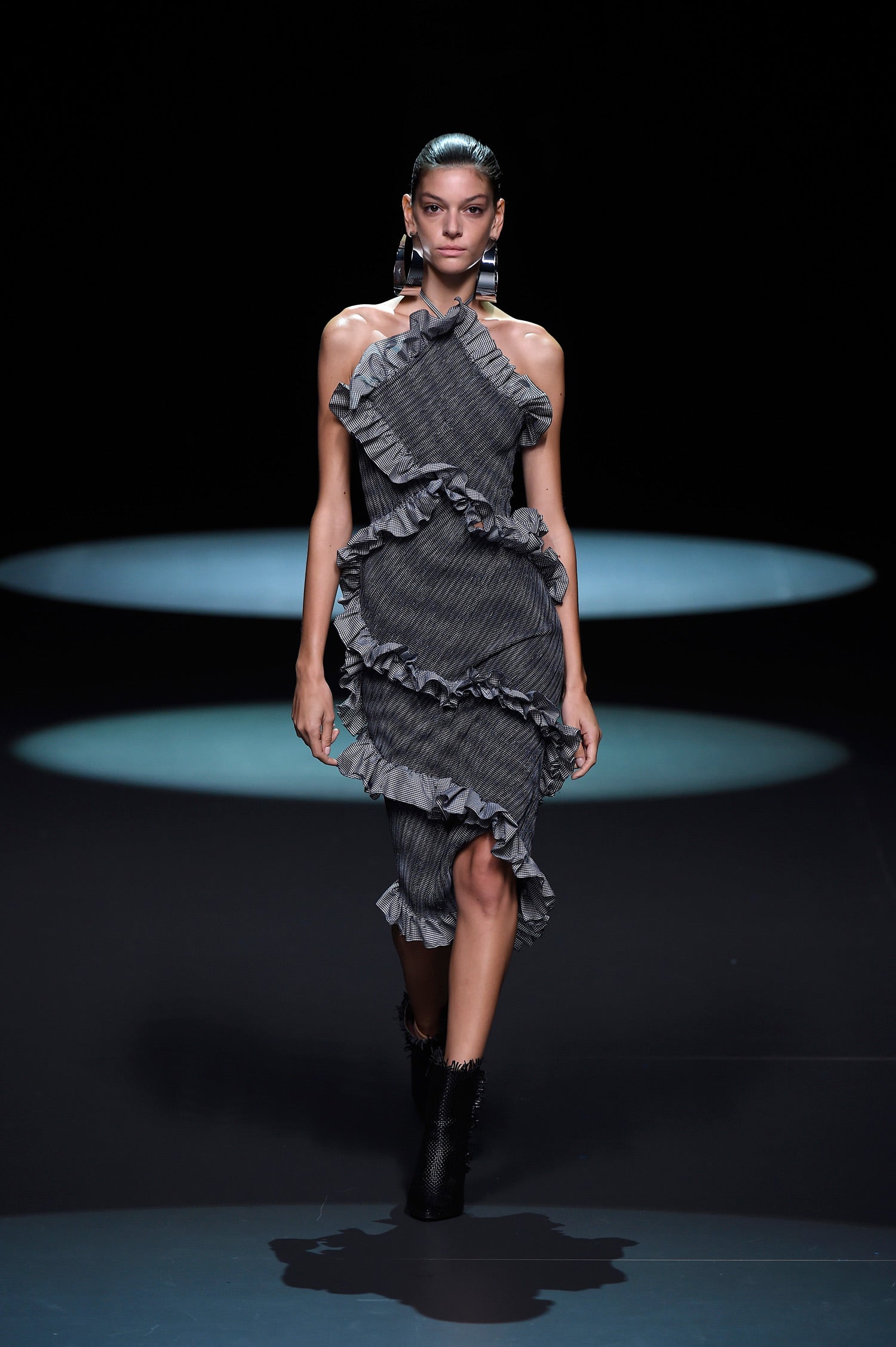 Vestido con volantes cruzados y maxi pendientes metálicos.