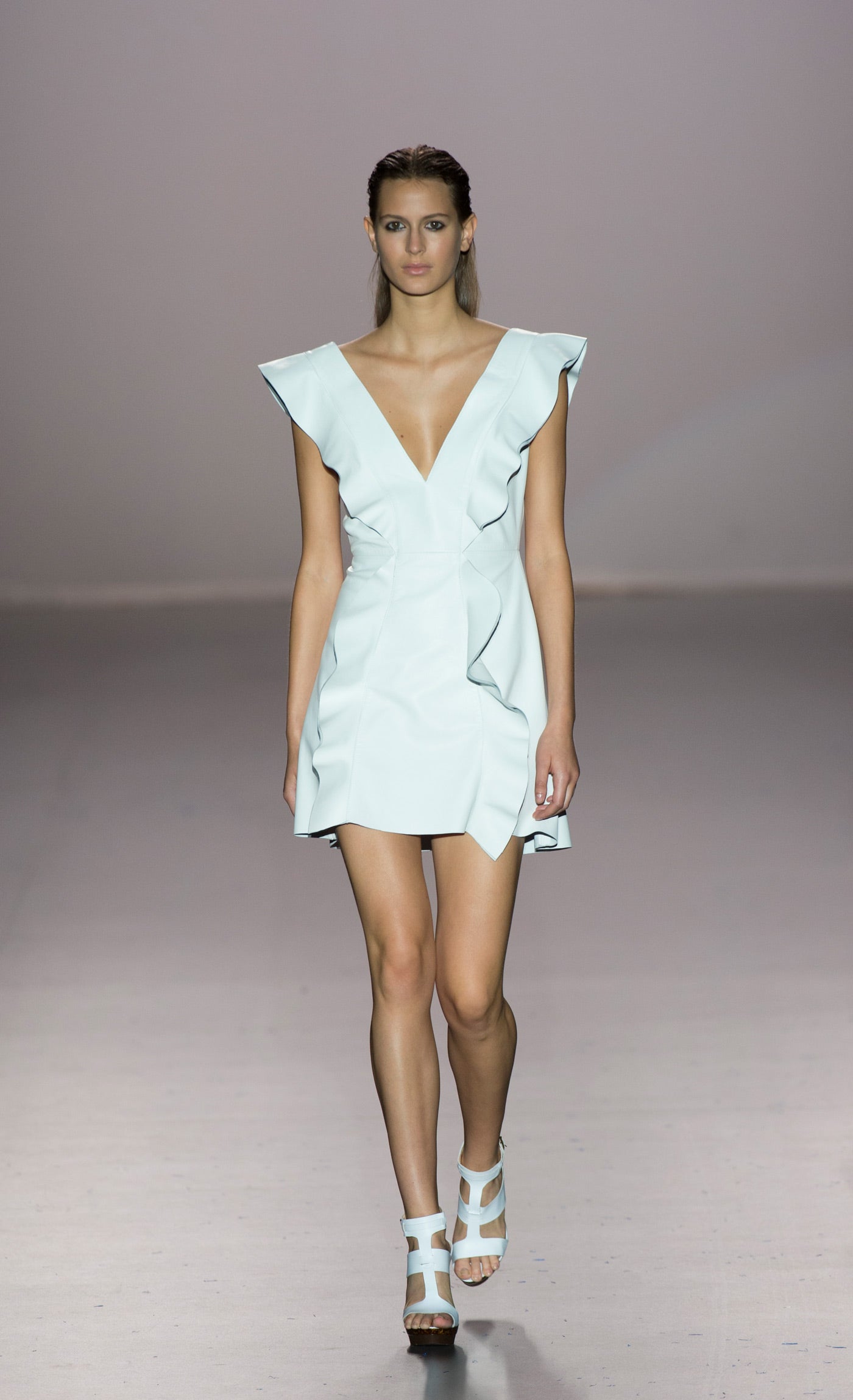 Vestido corto con escote y volantes verticales.