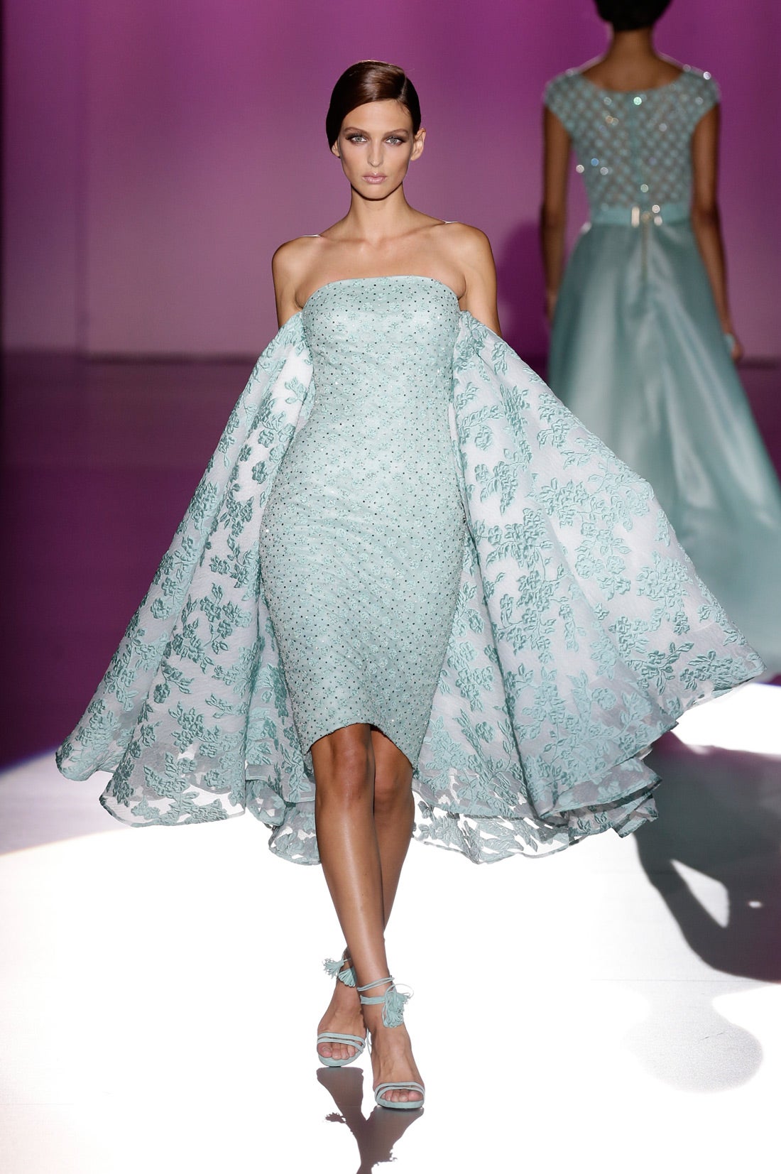 Vestido corto con escote de paabra de honor y capa en la espalda.