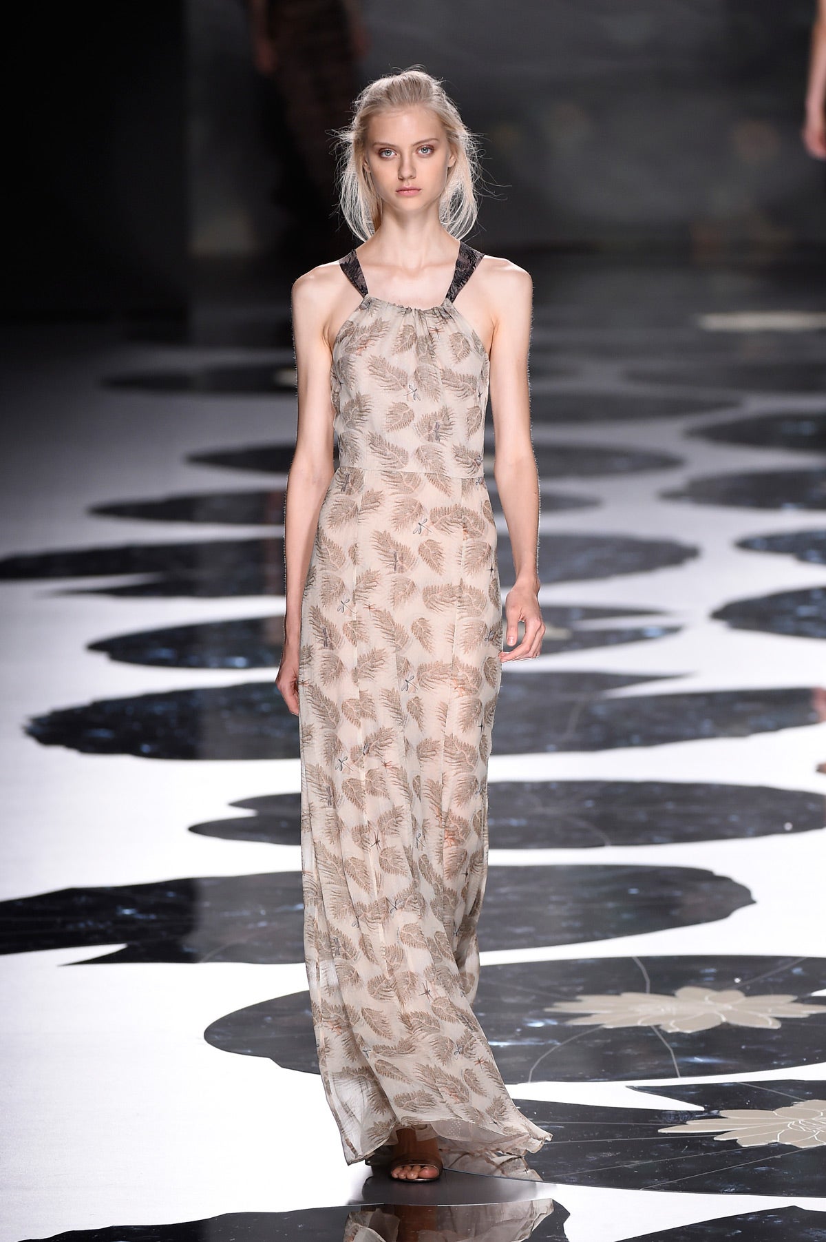 Vrestido largo con print de plunas sobre un fondo en color blanco roto.