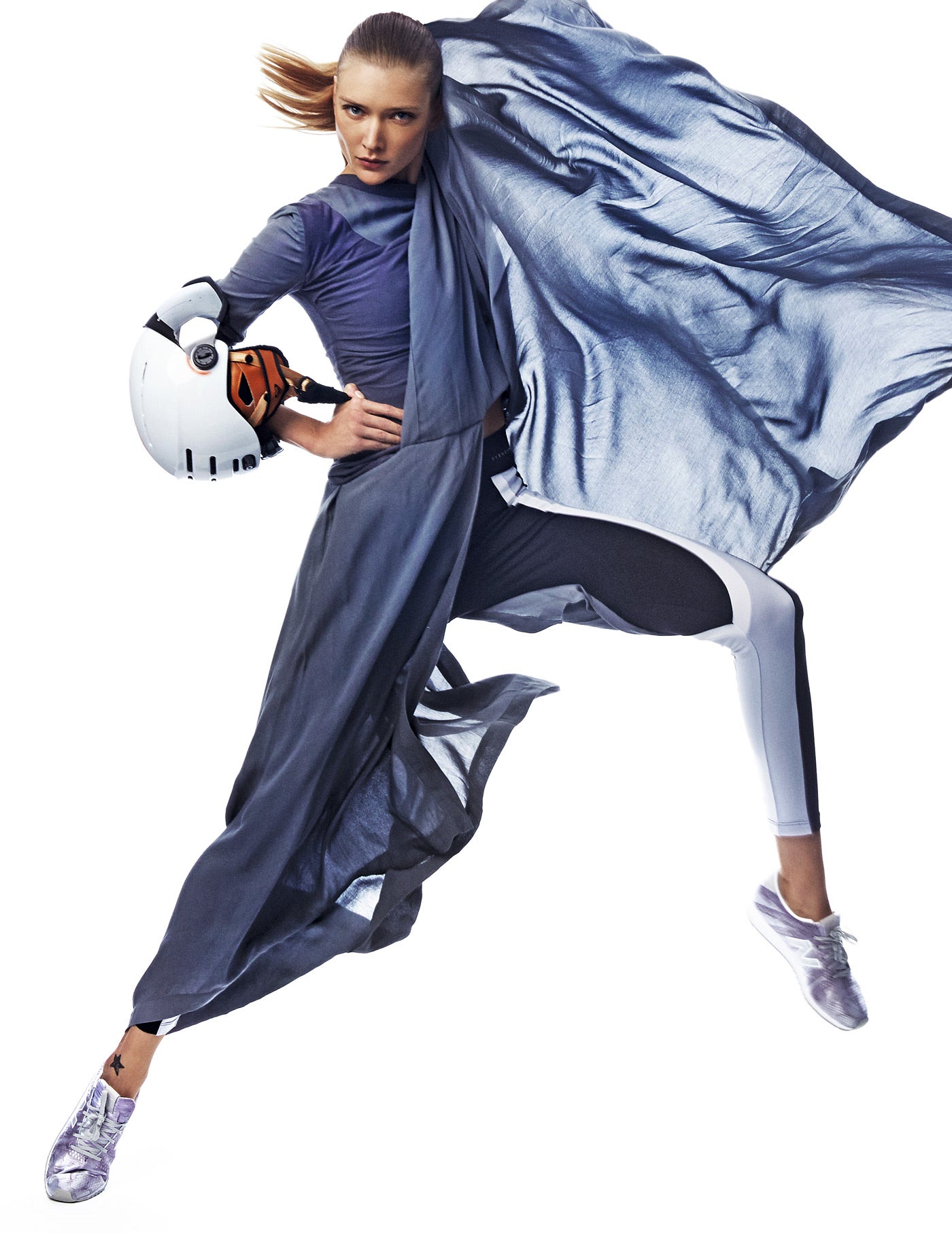 Vestido gris de capas, de Loewe. Las mallas son de Oysho; las zapatillas, de New Balance; y el casco, de Roxy. Estilismo: José Herrera. Maquillaje: LOréal Paris. Peluquería: Leo Pereira para Redken. Asistente de estilismo: Fran Jymz y Samuel Sanz. Asistente de fotografía: Yamel Jaltota.