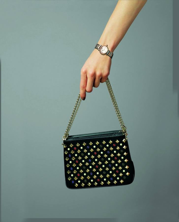 Reloj en acero, de Penélope Cruz para Viceroy; y bolso Triloubi, en ante, cuero y tachuelas, de Christian Louboutin.