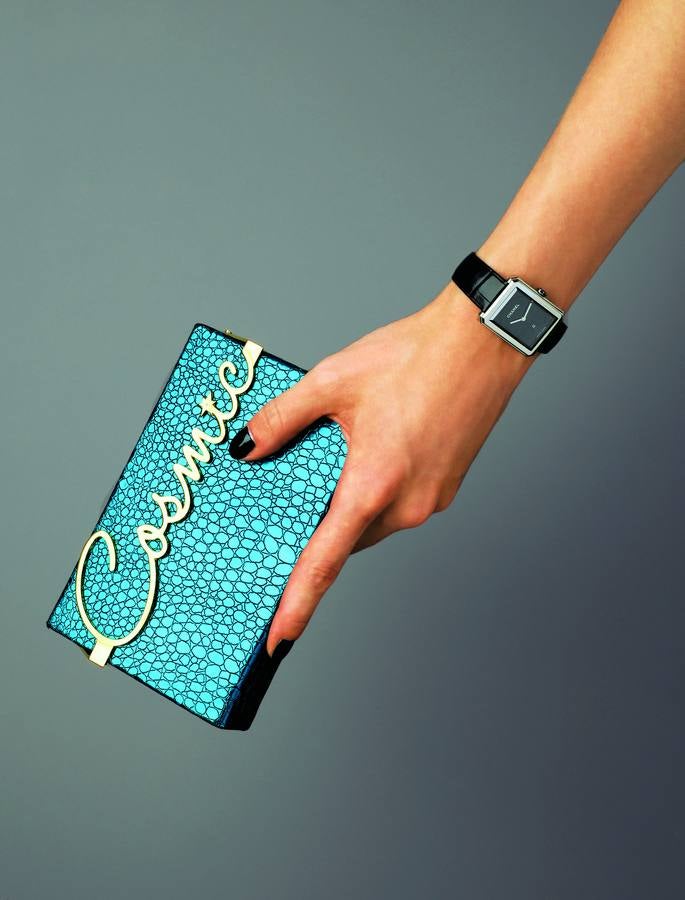 Reloj Boyfriend, de acero con correa de piel de cocodrilo, de Chanel; y clutch Cosmic, en piel con cierre metálico en dorado, de Charlotte Olympia.