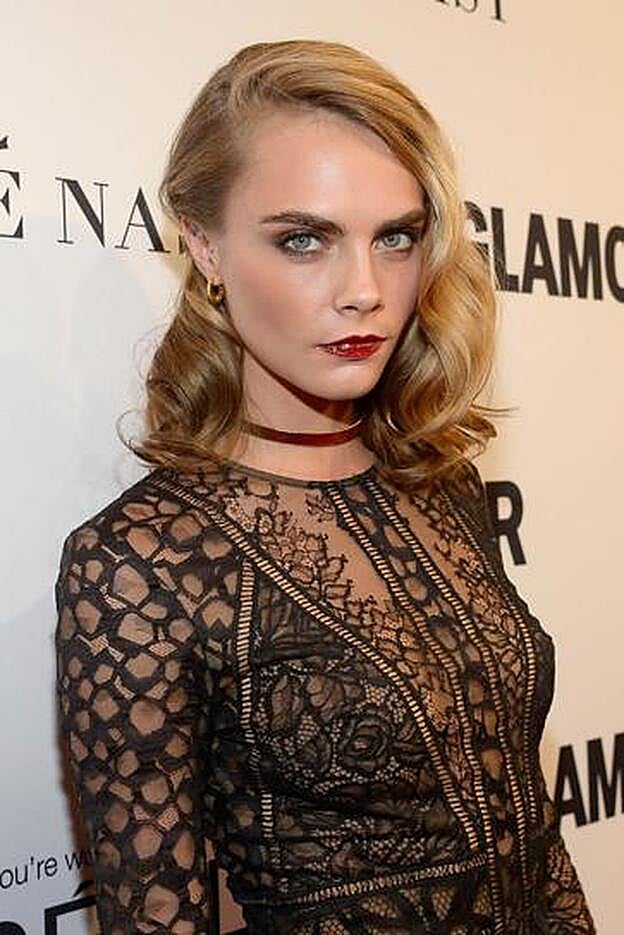 Cara Delevingne acudió a una fiesta en Hollywood con su melena midi peinada con ondas retro y unos bonitos labios de color rojo con acabado vinilo.