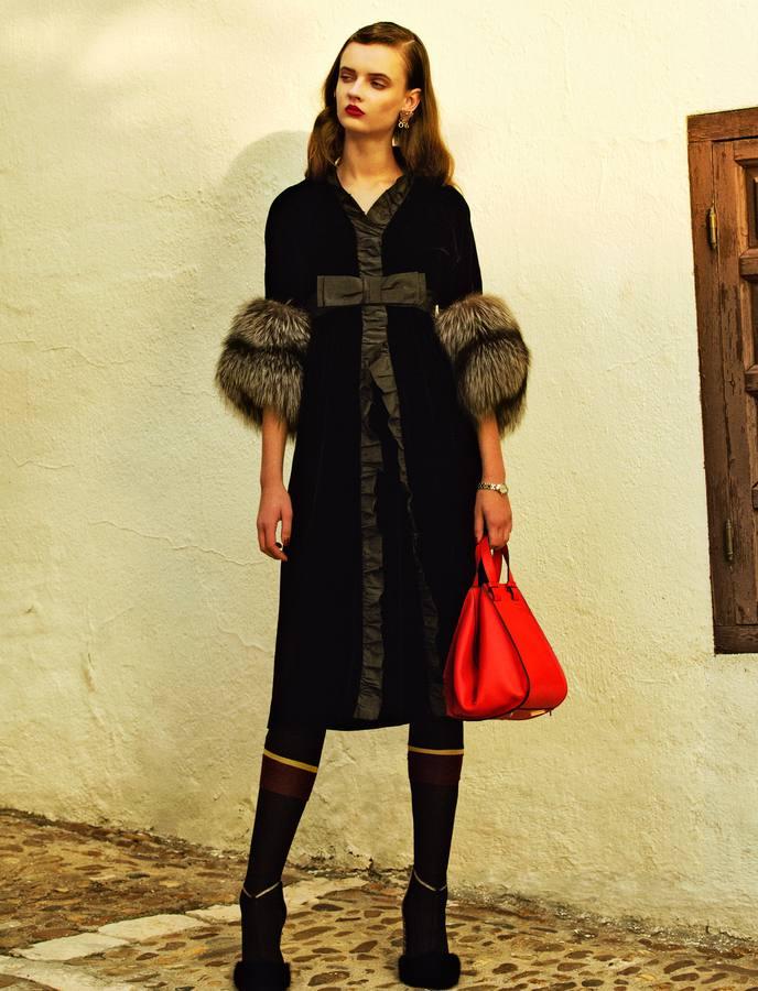 Vestido de terciopelo con detalles de zorro de Miu Miu, que también firma las medias. Sandalias de Salvatore Ferragamo, bolso modelo Hammock y pendientes de Loewe. Reloj de Rado.