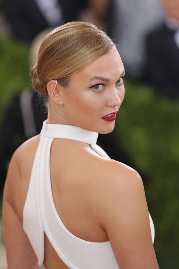 El moño más sencillo, el de bailarina, que puedes hacerte con un donut para que te salga más redondo y puedes llevar alto o bajo, es un peinado perfecto para tus cenas de Navidad. Puedes peinar tu pelo hace atrás, con raya en el medio o a un lado y acabado wet como Karlie Kloss.