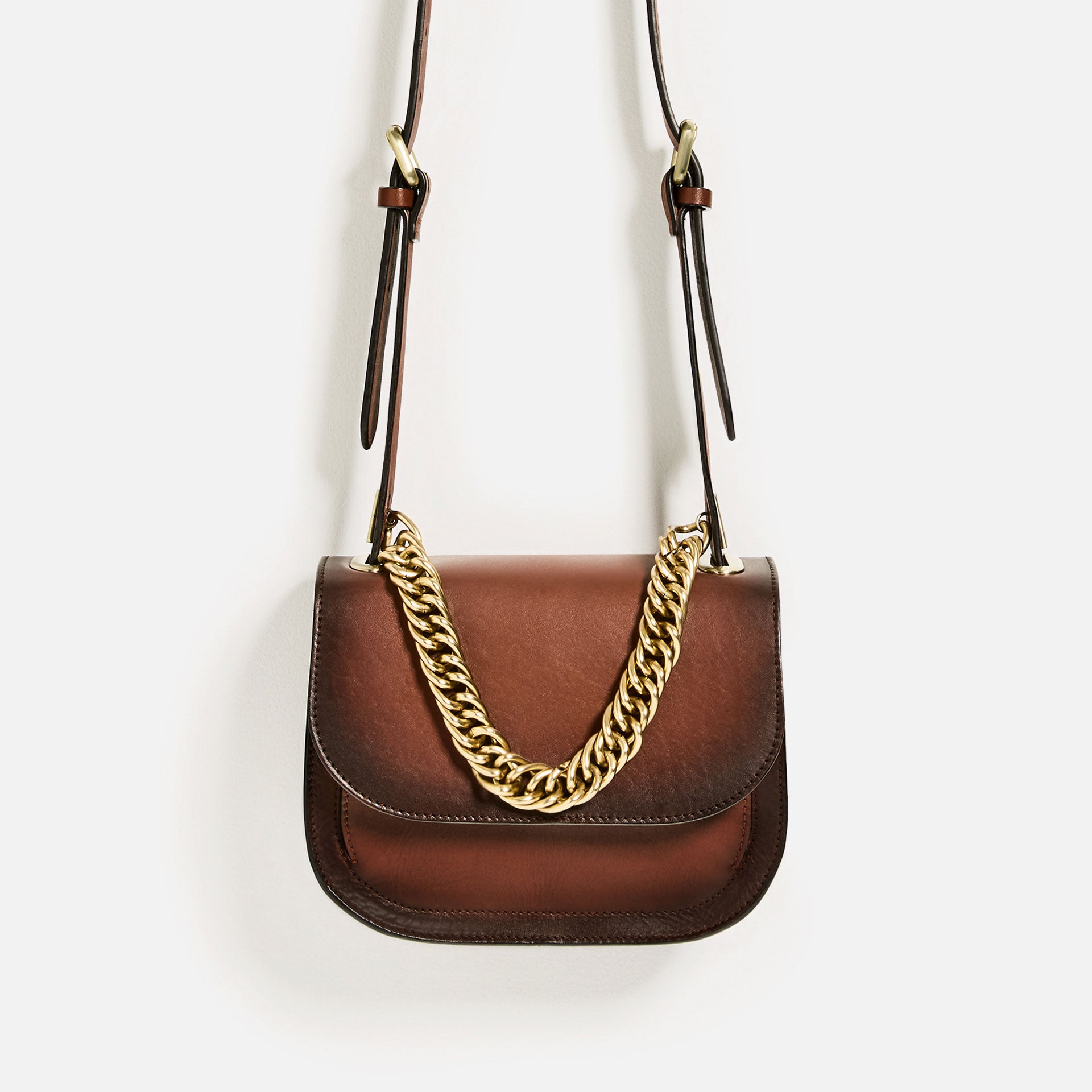 Bolso de piel en color cuero con asa larga y detalle de cadena dorada de Zara (59.99 euros)