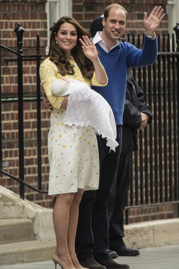 En mayo de 2015 Kate Middleton presentó a la prensa a la princesa Charlotte con un vestido amplio que ocultaba su tripita con estampado de flores amarillas, media manga y cuello redondo de Jenny Packham que combinó con unos salones nude de L.K. Bennett.