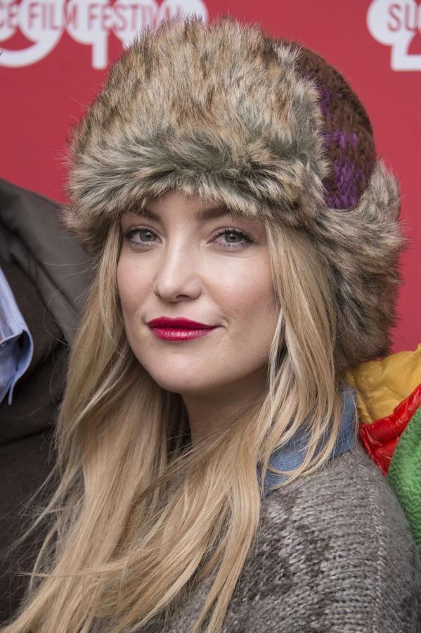 La actriz Kate Hudson con gorro ruso que combina con la melena suelta lisa y con unos bonitos labios rojos. Un look abrigado perfecto.