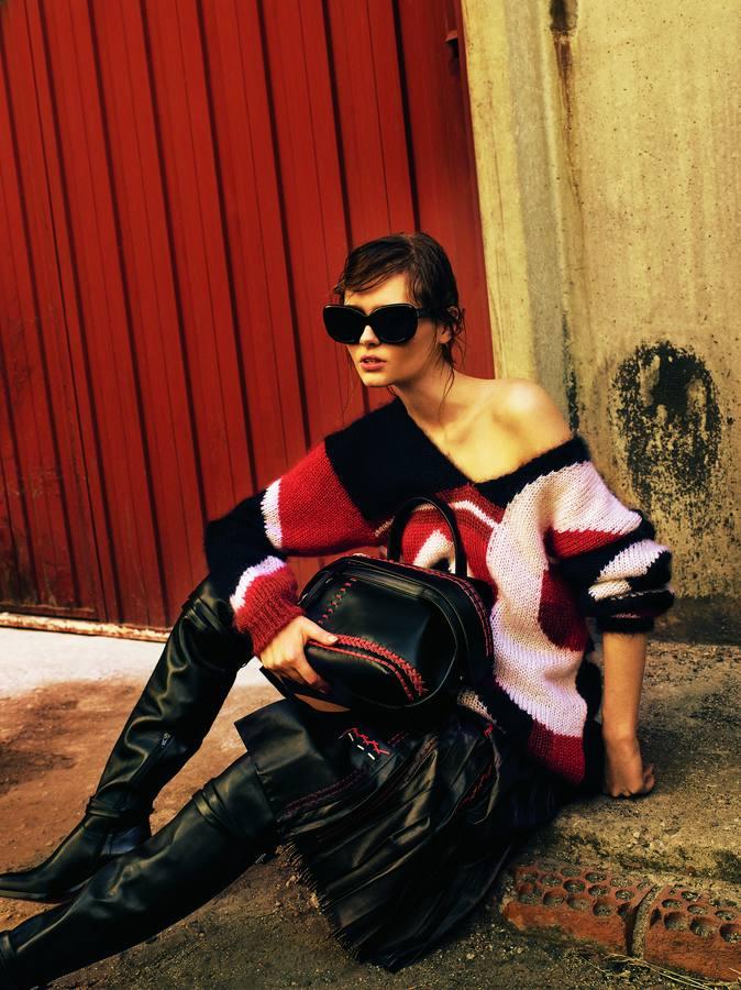 Jersey oversize, falda de cuero tableada y bolso, todo de Tod's. Las botas son de Chritian Louboutin y las gafas de Céline.