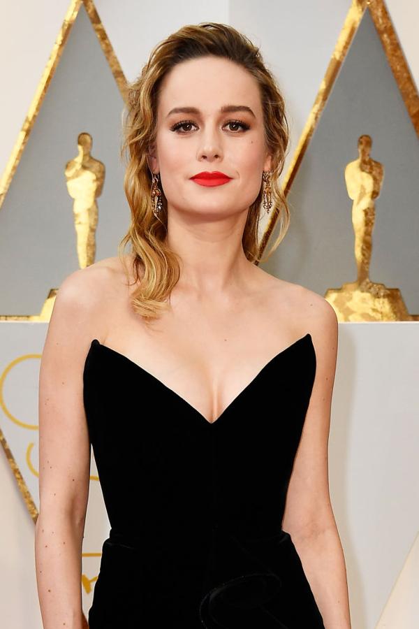 Brie Larson lució un semirrecogido con el pelo ondulado y un maquillaje que no falla: labios rojos con acabado mate, eyeliner negro y pestañas XXL.