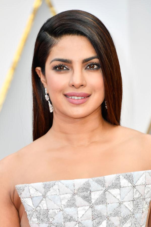 Priyanka Chopra lució melena suelta, lisa y muy pulida, con raya lateral baja. En su maquillaje destacan las sombras glitter en tono gris, y los labios naturales.