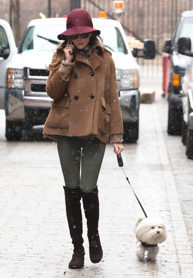 Olivia Palermo opta por botas de caña alta, abrigo en color camel y gorro de color teja.
