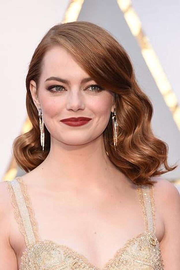 Emma Stone, la pelirroja del momento, con labios rojos oscuros, sombras glitter en tono beige, eyeliner marrón y un toque de colorete rojizo en las mejillas.
