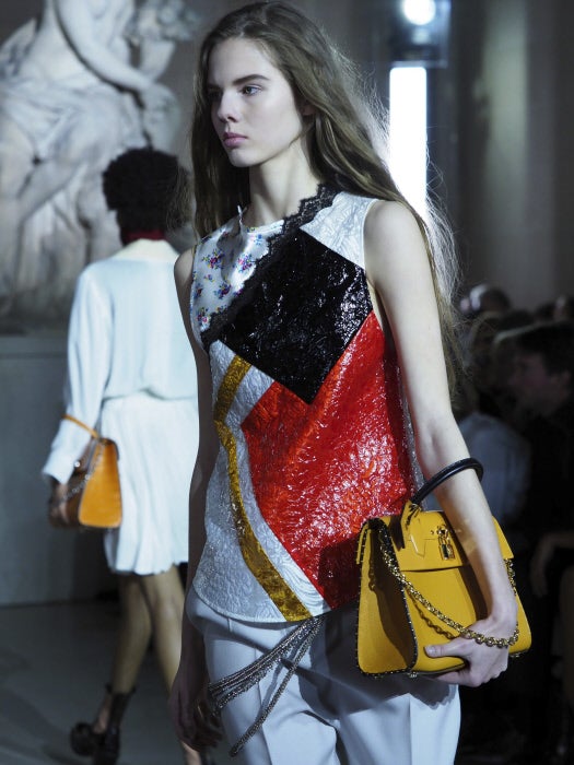 Aunque las modelos lleven pantalones de pinzas, la formalidad se rompe gracias a los cinturones de cadenas que cuelgan de un lateral del pantalón.