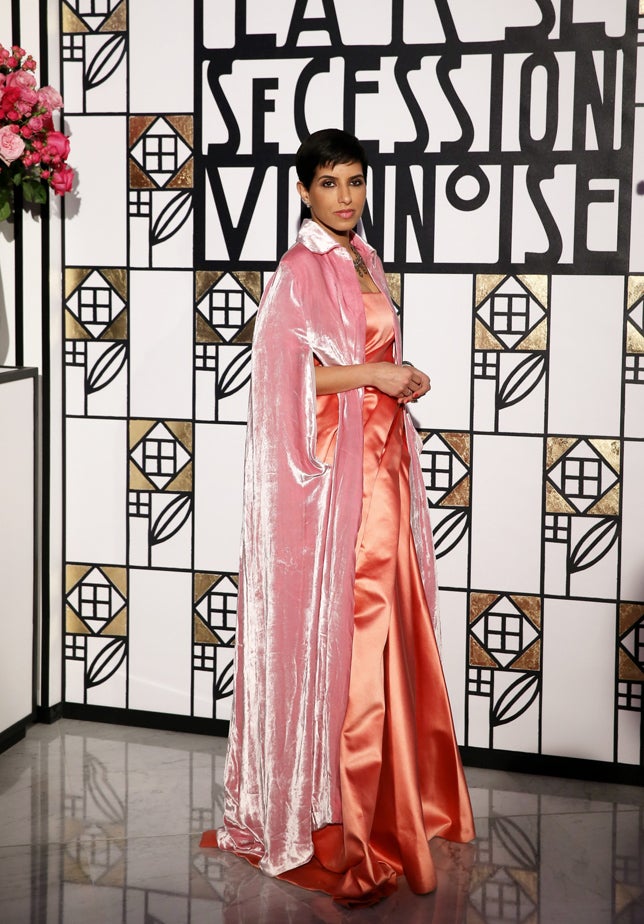 La Princesa Deena Aljuhani Abdulaziz tampoco nos convence con esta combinación imposible de vestido de seda coral y capa de terciopelo rosa: ni los tejidos, ni los colores ni las siluetas tienen sentido alguno en esta mezcla.