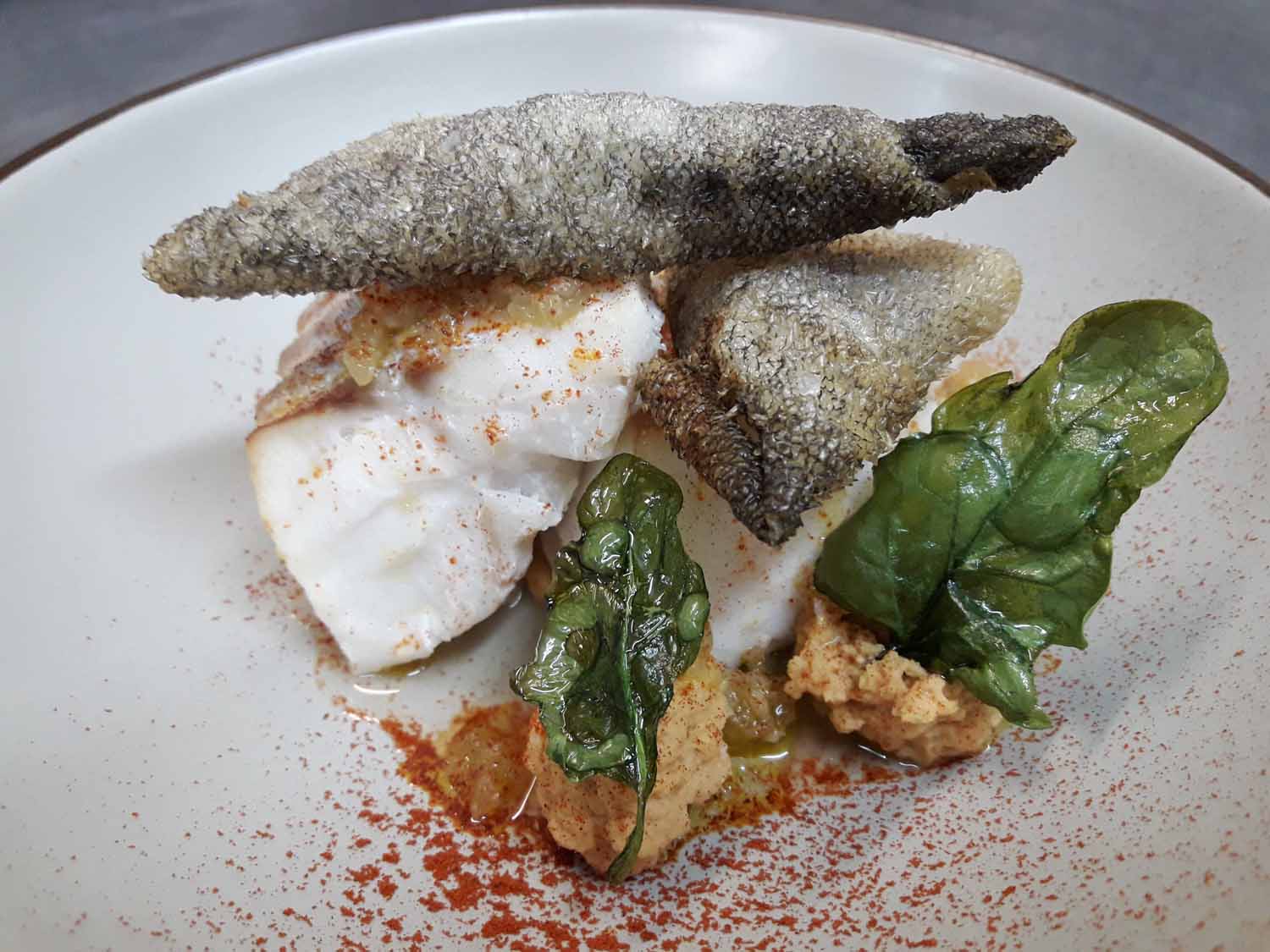 El 'potaje a la manera de El Mendrugo' (calle Colmenares, 5, Madrid) propone un plato que no es de cuchara, sino que sirve tajadas de skrei con crema untuosa de garbanzos y texturas de espinacas.