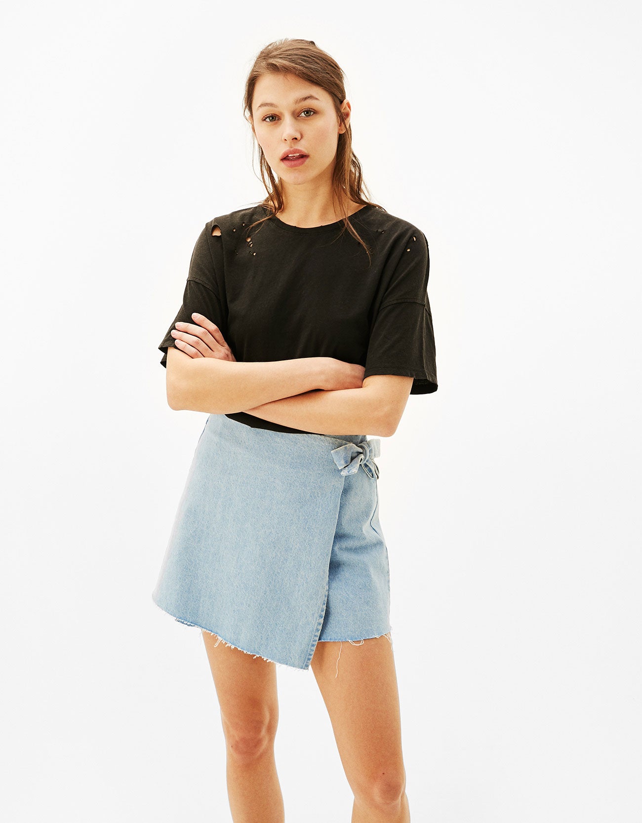 Camiseta negra con rotos de Bershka. Precio: 12,99 eruos.