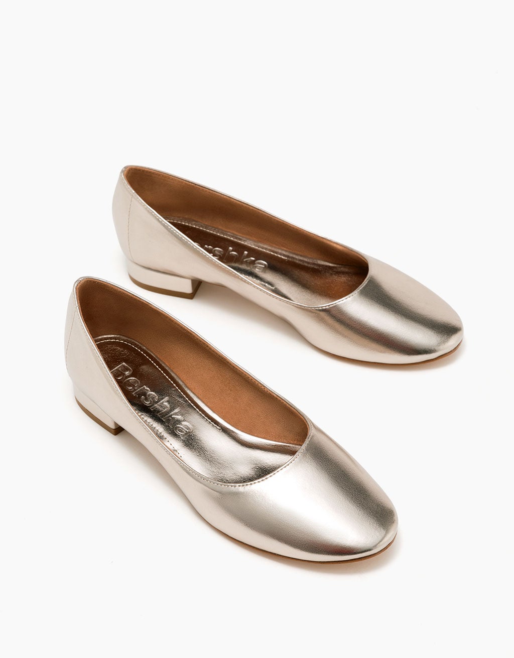 Bailarinas dorada con tacón bajo de Bershka (19.99 euros).