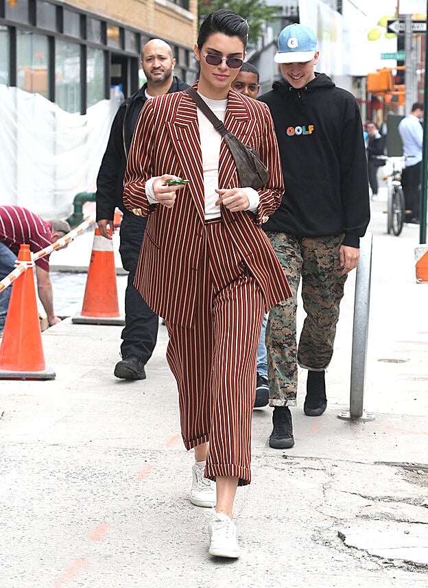 Kendall Jenner con un traje de rayas en versión 'cropped' y zapatillas deportivas