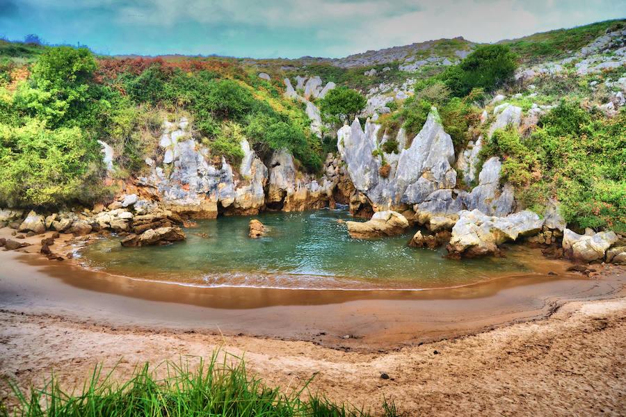 Escondida entre la costa de Llanes y la de Ribadesella encontramos la Playa de Gulpiyuri, que con sus escasos 50 metros es considerada por muchos como la más pequeña del mundo. Declarada monumento natural, el agua del mar entra en ella a través de un túnel formado entre las rocas, creando un enclave mágico en el que, además, es podemos caminar sobre las rocas bajo las cuales pasa el agua haciendo lo que en Asturias se conocen como 'Bufones', el ruido que hace el agua del mar al pasar a presión por los túneles de la orilla.