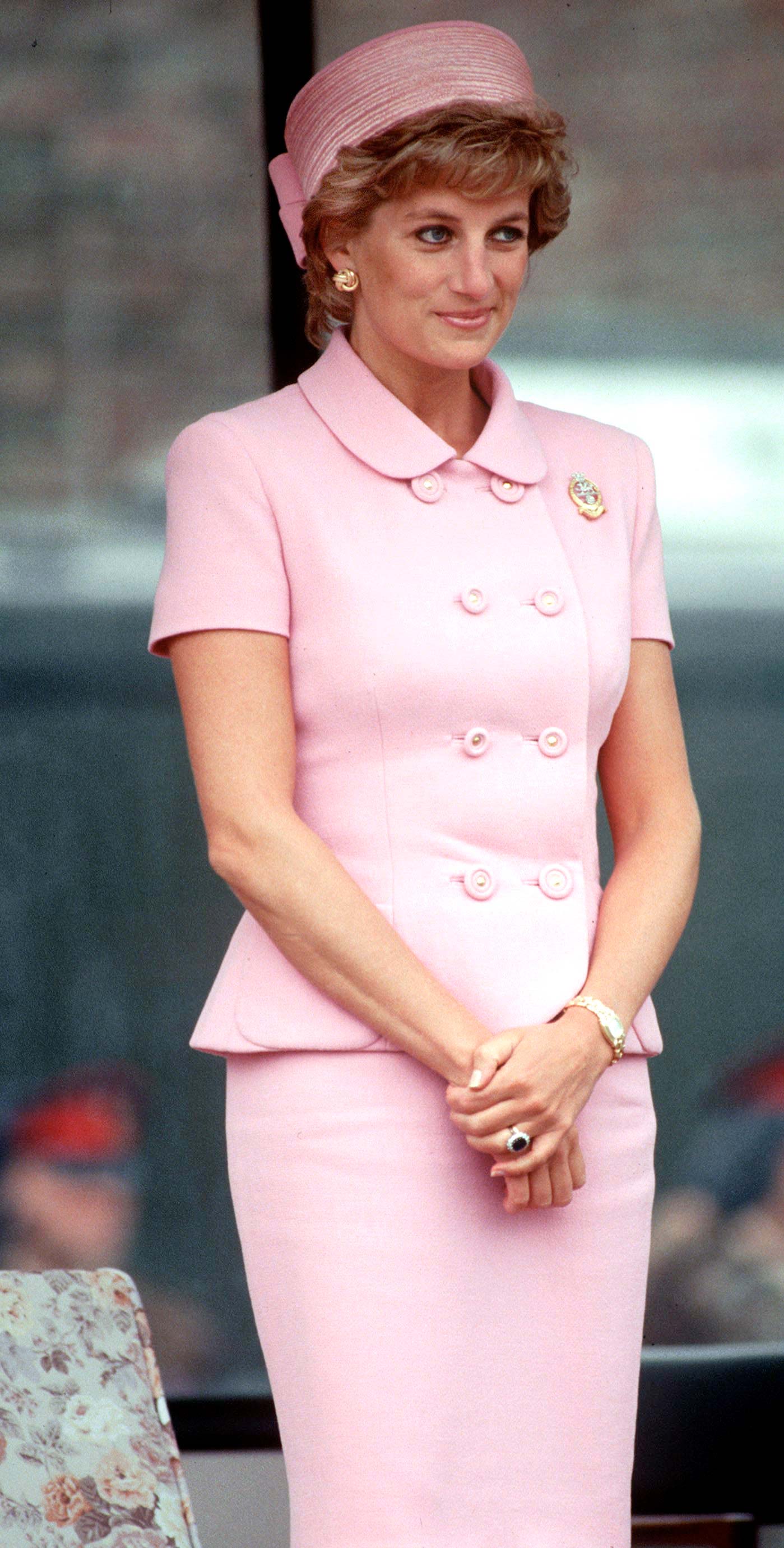 Diana de Gales luciendo un traje de falda larga y chaqueta en color rosa claro. Con accesorios de un reloj y un anillo.