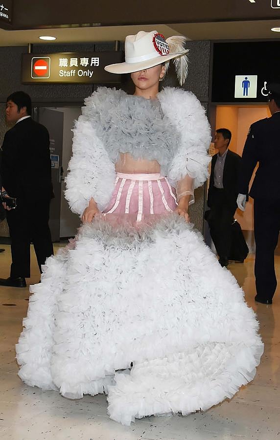 Lady Gaga en el aeropuerto de Narita en Tokyo. La cantante lleva una falda con mucho volumen en color blanco y un top del mismo tejido y el mismo color.