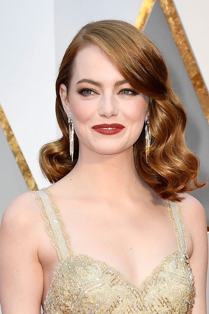 Si buscas un maquillaje más subido de tono, copia el de Emma Stone. Ojos con sombras en color beige y acabado irisado en tono el párpado para conseguir un plus de luminosidad en la mirada. Y labios oscuros con un granate semimate. Un maquillaje más adecuado para una boda de noche.