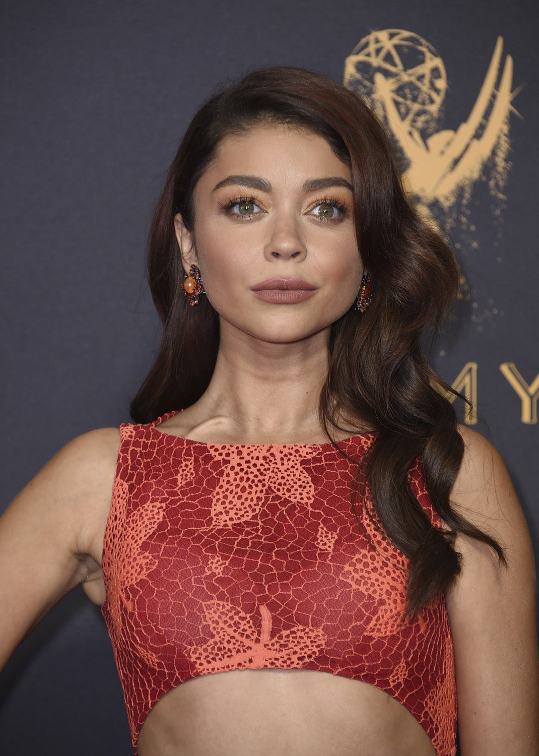 La protagonista de 'Modern Family', Sarah Hyland, con melena suelta con ondas, labios marrones y sombras doradas.