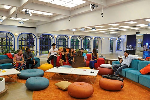 Los concursantes de la casa reunidos en el salón de Gran Hermano Revolution. Con sofases de colores y 'pufs', también de diferentes colores.
