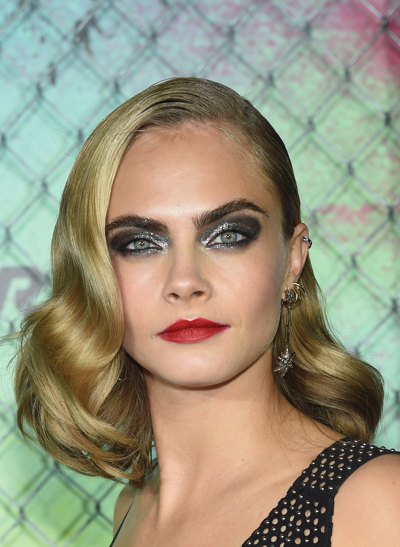 Un maquillaje solo acto para atrevidas. Cara Delevingne combinó los labios rojos con una mirada súper sexy a base de sombras metálicas en tonos grises.