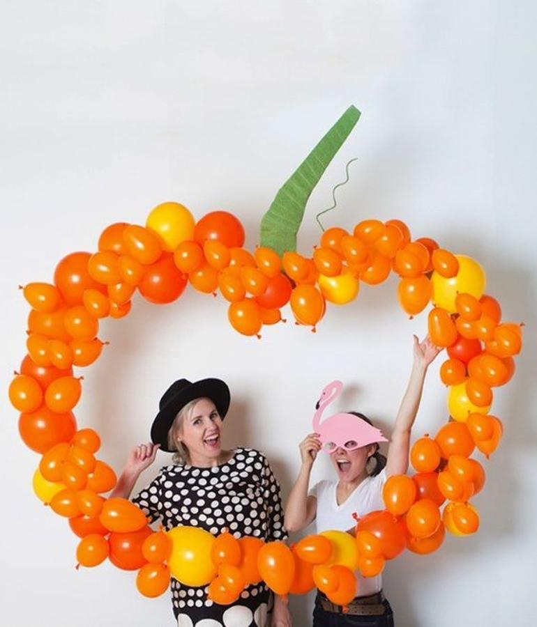 Si las bodas tienen 'photocalls'... ¿por qué no tú fiesta de Halloween? Este heho con globos en forma de calabaza ¡es genial!