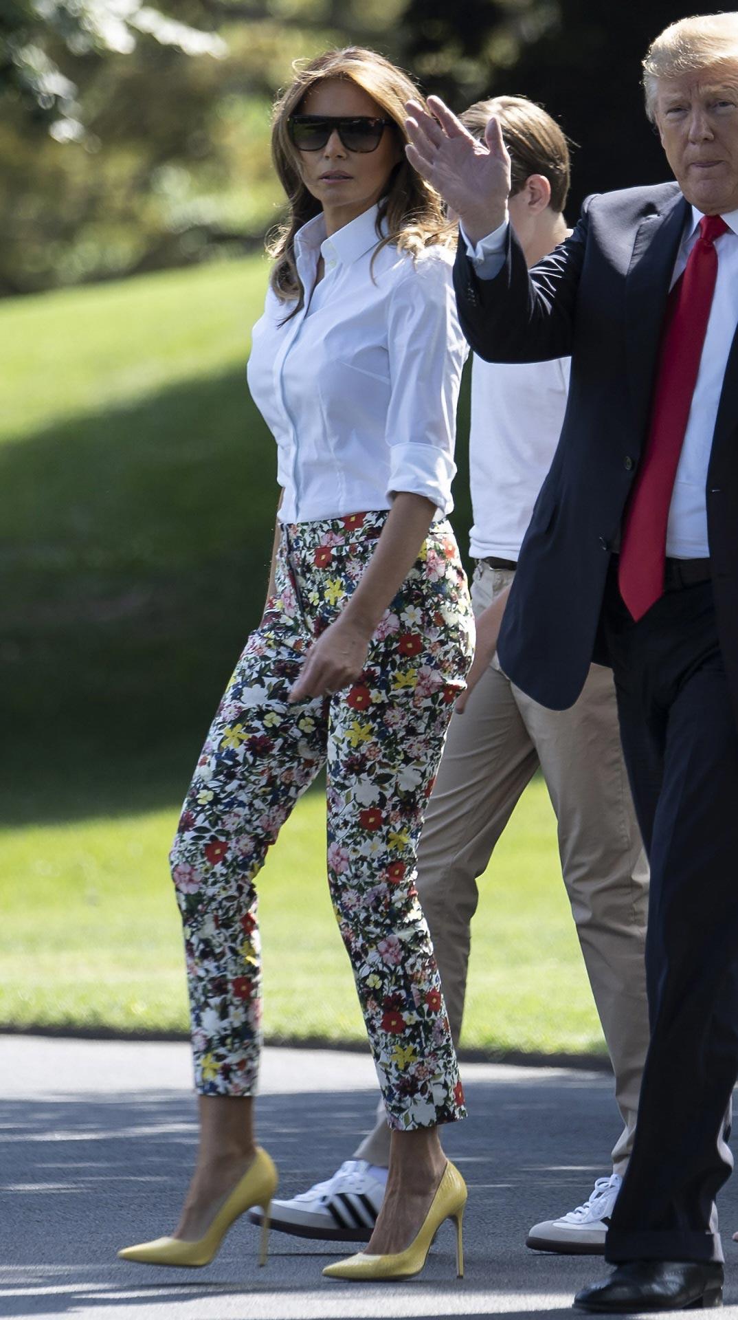 A Melania le encantan las camisas blancas. Apuesta por ellas para casi todos sus viajes o para sus citas informales como esta, en la qeu la combina con un pantalón estampado. Una muy buena opción para un look vacacional.