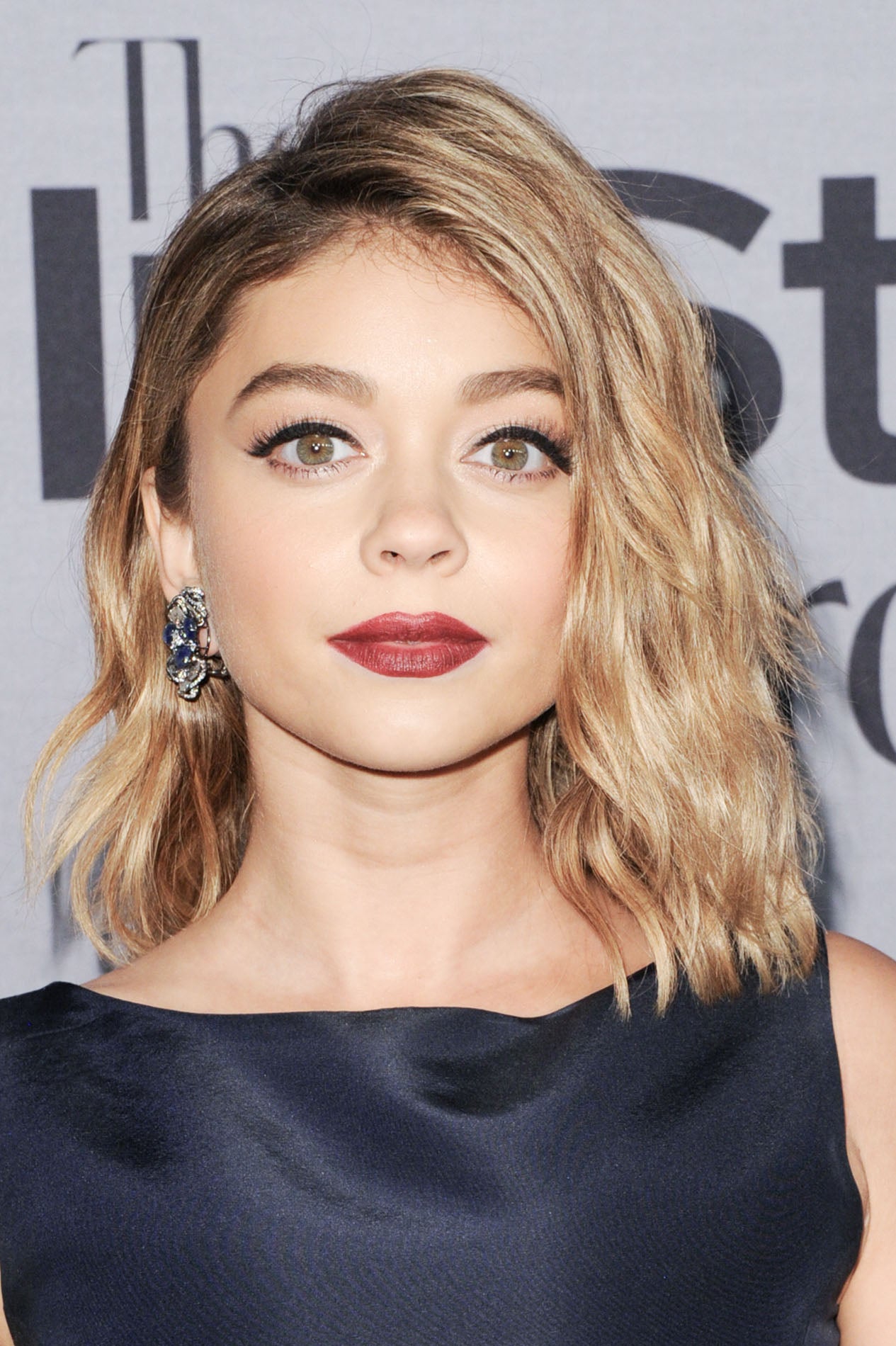 La actriz de 'Modern Family' Sarah Hyland llevan las raíces oscuras con un rubio ceniza, en subob ondulado.