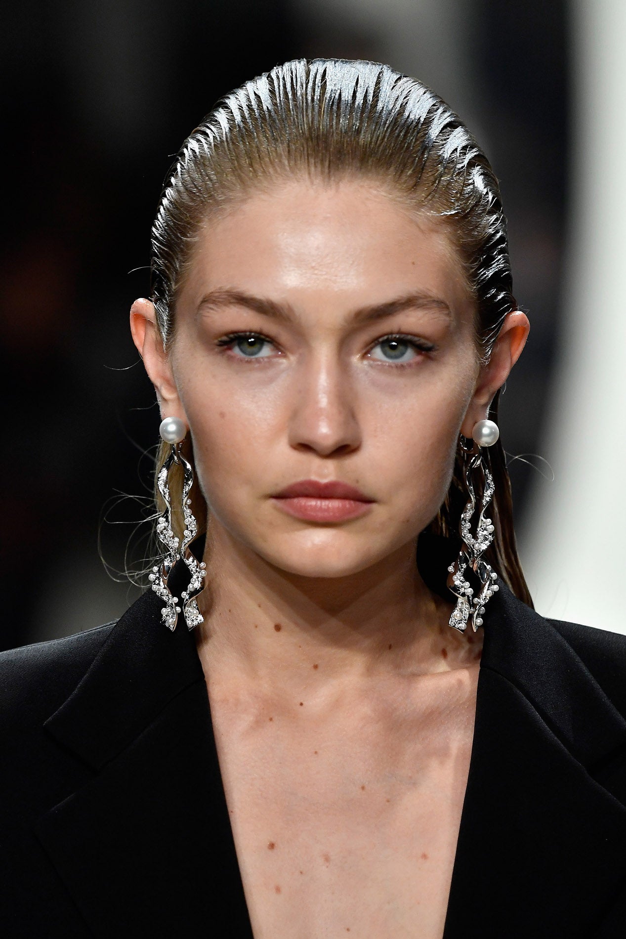 Un peinado súper sencillo que puedes lucir tanto en una melena larga como media y que te permitirá centrar toda la atención en los maxi pendientes: peina hacia atrás y aplica gomina, cera o cualquier fijador para conseguir un acabado 'wet' o mojado.