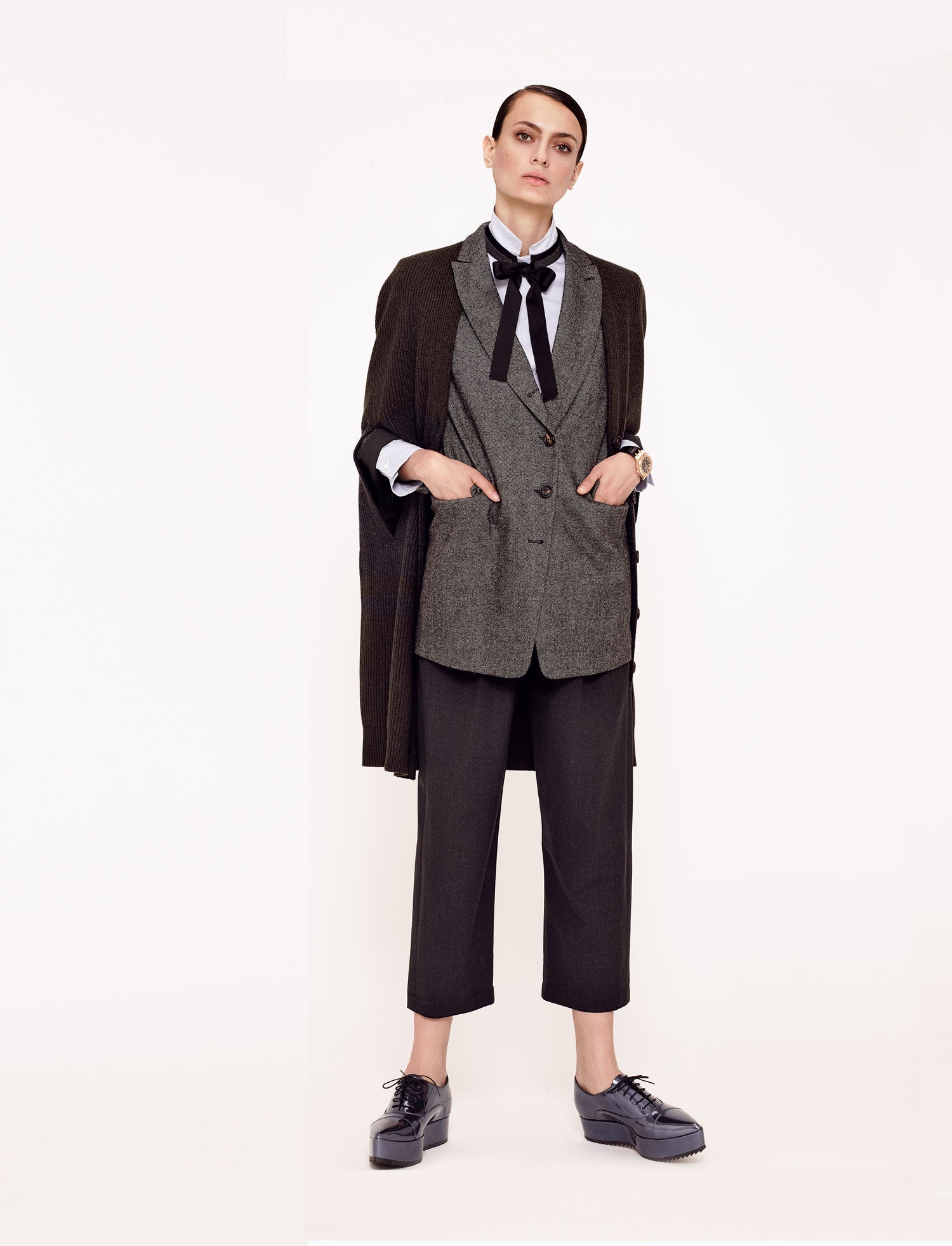 Capa de punto, blazer, pantalón y camisa con lazada, todo de Brunello Cucinelli. Zapatos de Pedro García y reloj de Audemars Piguet.