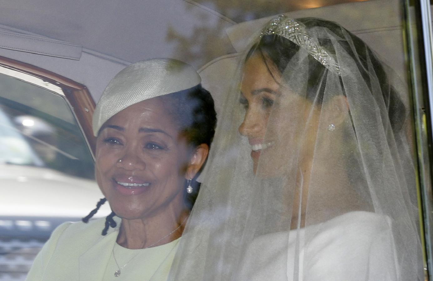 Meghan Markle ha salido del hotel donde ha pasado su última noche de soltera en compañía de su madre. Montada en un Rolls Royce de la colección privada de la Reina Isabel II, hemos visto la primera foto de Meghan Markle con su vestido de novia para su boda este 19 de mayo de 2018.