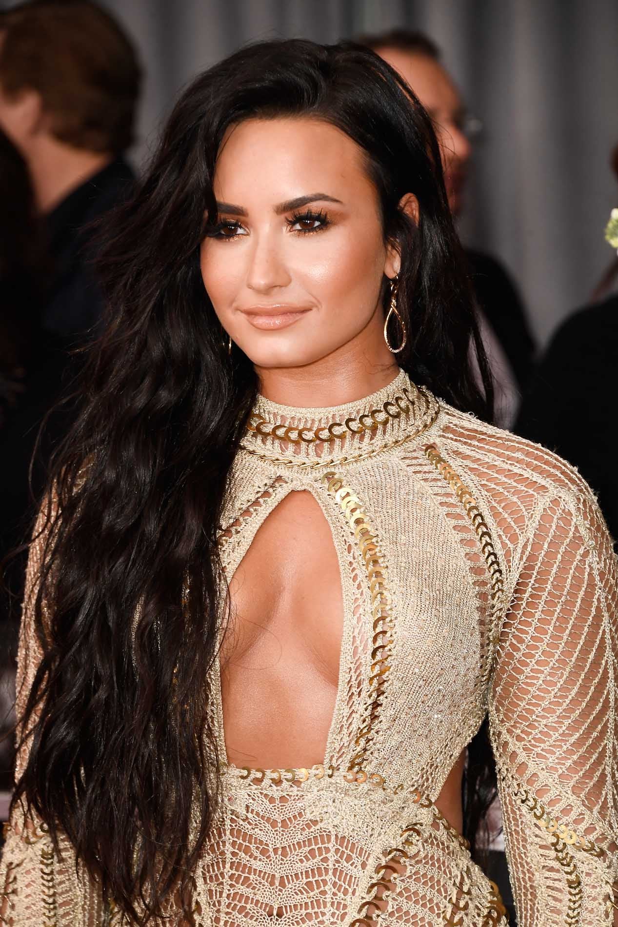 Demi Lovato con sombras doradas, eyeliner negro, pestañas XXL y labios nude en los Grammy 2017.